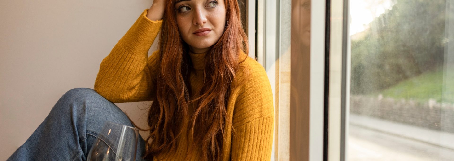 caucasian woman at home sad on the floor with a glass of wine - concept of addiction,